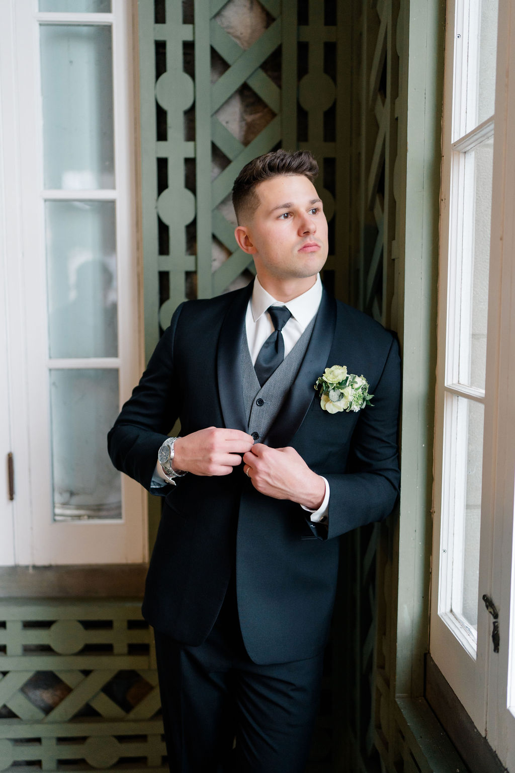Rhode Island Wedding Photographer | Newport Wedding Photography Caprio Captured | Groom standing by the window fixing his suit
